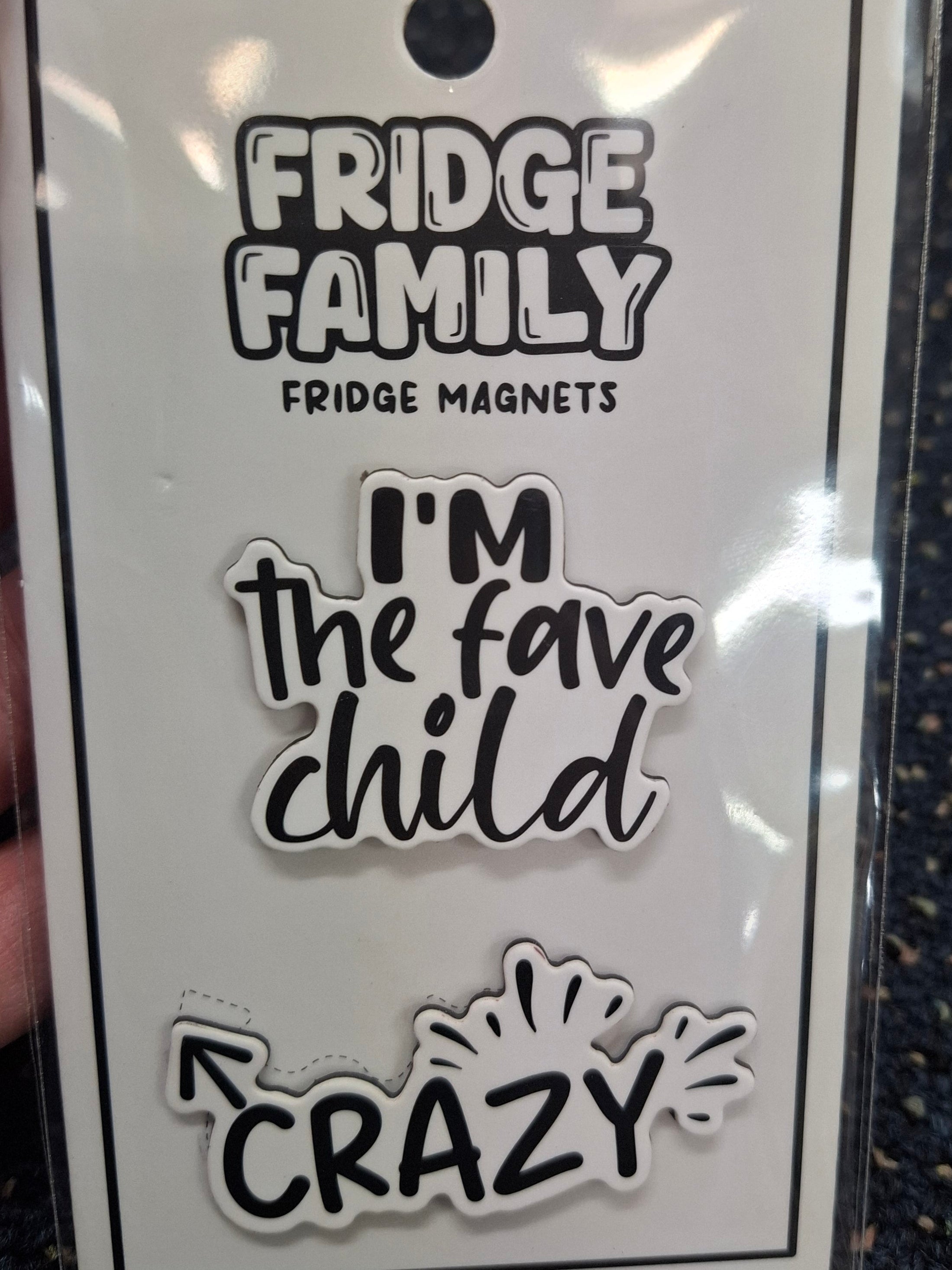 Packaging of Fridge Family fridge magnets with text on a dark textured background